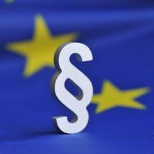 Paragrafenzeichen vor europäischer Fahne